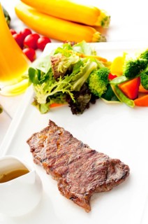 Juicy BBQ grilled rib eye, ribeye steak, vegetables and lagher beer on background, MORE DELICIOUS