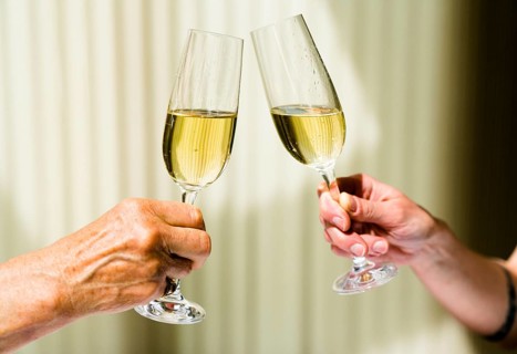 detail view of a grandmother toasting with champagne glasses with her daughter