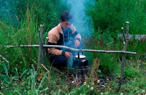 Man at campfire in taiga, Kamchatka, Russia, Europe