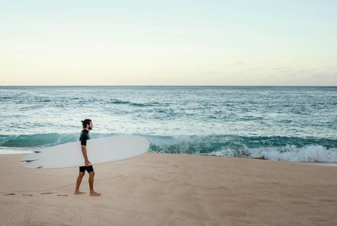 Man holding his surfing board ocean