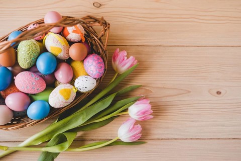 Tulips near basket with easter eggs