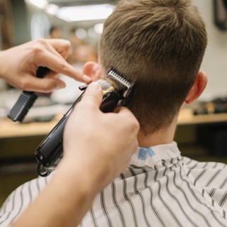 Back view man getting haircut
