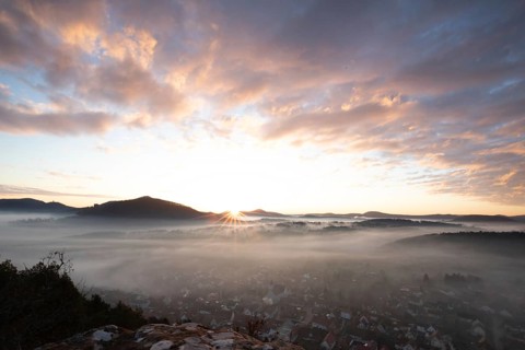 Mystical sunrise at the Wachtfelsen. Fascinating landscape shot between fog and clouds near
