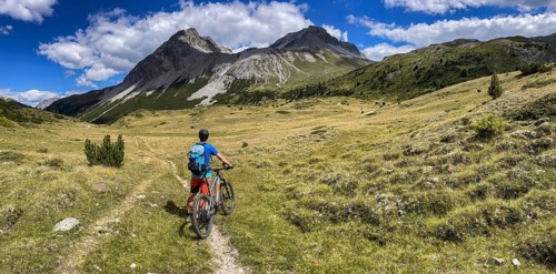 Mountain bikers on the Pass da Costainas with Piz Starlex and Piz Murtera with Foppa da Tamangur