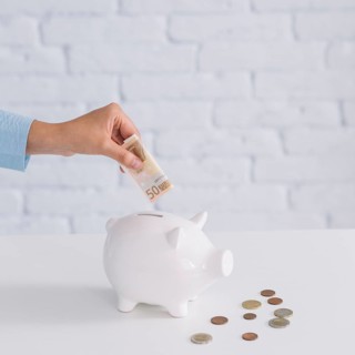Close up woman s hand inserting fifty euro banknote piggybank desk. Beautiful photo