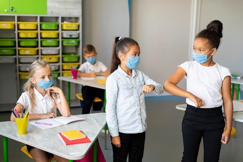 Kids elbow bumping classroom