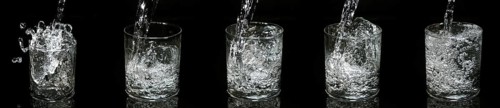 Water being poured into Glass against Black Background