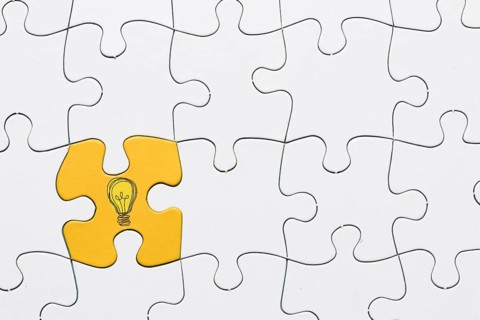 Idea icon yellow puzzle piece connected with white grid puzzle backdrop. Resolution and high