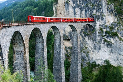 Red train of swiss Rhätische Bahn, Rhaetian Railway Company or Glacier Express on Viaduct