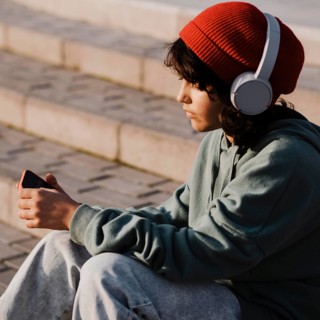 Teenager outdoors using smartphone listening music headphones