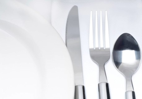 Close up of a cutlery set on a table with napkin and dish