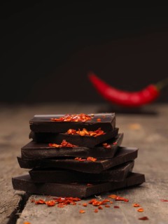 Pile of chocolate with chili flakes on a rustic wooden table