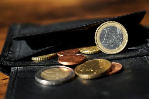 black leather wallet with euro and cent coins close-up