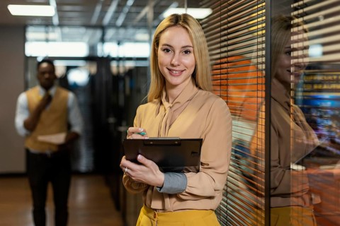 Smiley woman holding clipboard workplace