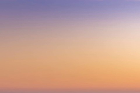 A gradient sunset sky background from orange and red to lilac and blue