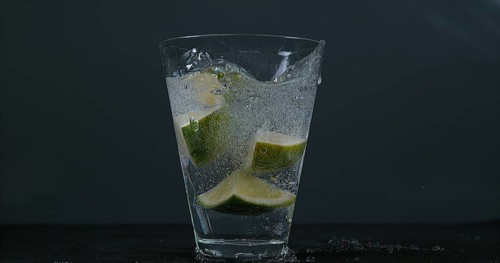 Green Citrus (citrus aurantifolia), falling into a Glass of Water