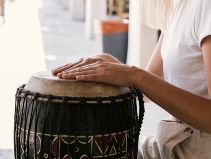 Young person playing latin percussion instrument