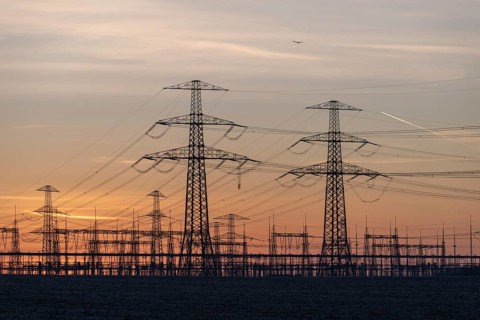 Rows of high-voltage pylons stretch into the twilight, Wolmirstedt substation, Saxony-Anhalt,