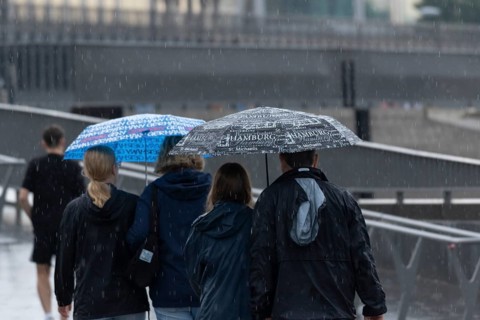 Symbolic picture weather, heavy rain in summer, thunderstorm, thunderstorm, tourists with umbrellas