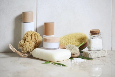 Face cream, serum, lotion, moisturizer and sea salt among bamboo leaves in the bath
