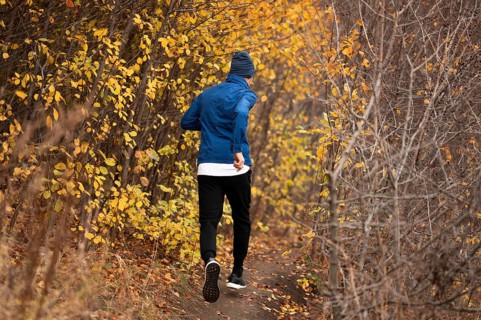 Full shot man running trail forest