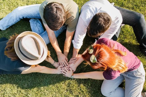 group adult friends putting hands together