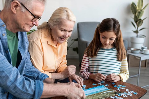 Grandparents girl doing puzzle close up