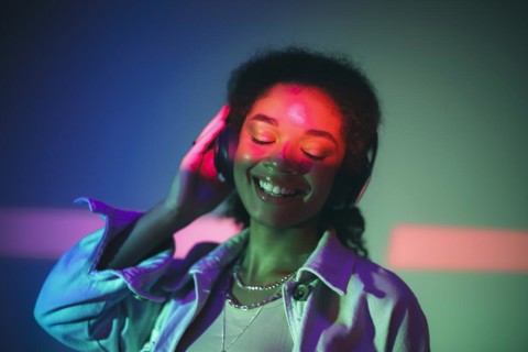 Young happy african american woman in black headphones listening to music, enjoying high quality