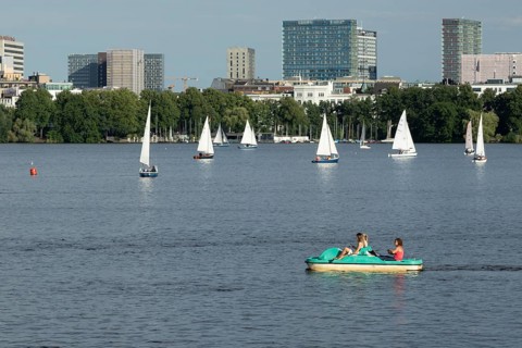 Symbolic picture weather, leisure activities in summer, people in a pedal boat, behind them sailing