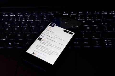 Symbolic image social media, close-up of a smartphone on an illuminated computer keyboard with X