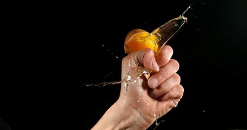 Hand of woman with a Chicken Egg against Black Background