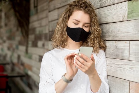 Female with mask using phone