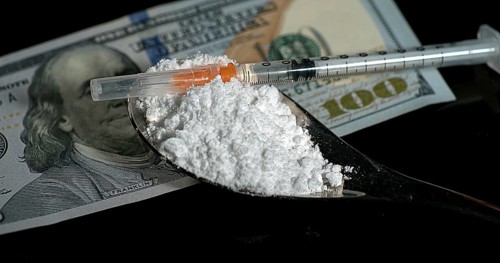 Dollar Bank notes and Siringa with Powder Drug against Black Background