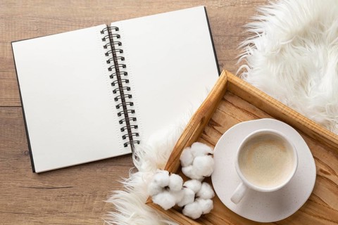 Top view notebook with cup coffee cotton flowers