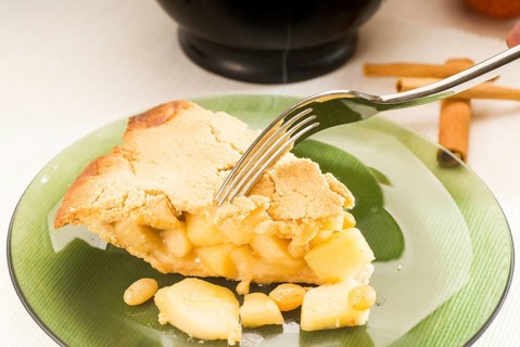 Fresh homemade apple pie over green glass dish macro colseup eating with fork