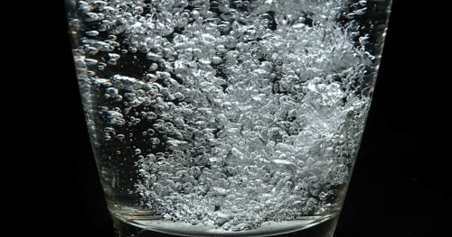 Water being poured into Glass against Black Background