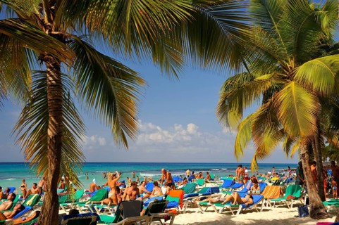 Holidaymakers on a tropical beach, Bayahibe, Dominican Republic, Central America