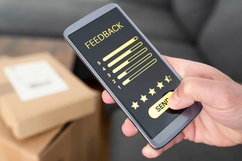 close-up of person giving positive feedback on smartphone after delivery of ordered items, customer