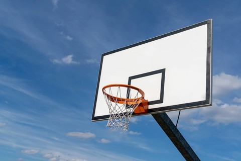 isolated view of a basketball hoop and backboard under an expressive blue sky with copy space
