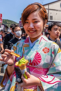 Kyoto Japan. Smiling woman wearing traditional kimono, eating an ice cream