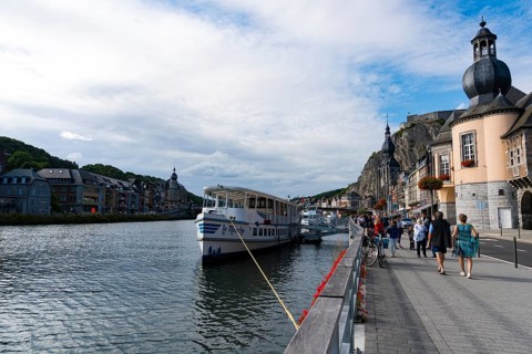 Belgium - 11 August 2019: horizontal view of tourists enjoying an evening walk along the Meuse