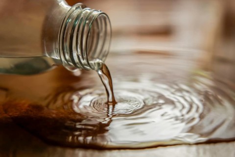Close-up shot of a plastic water bottle spilling water on the ground