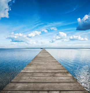 Old wooden pier on big blue lake