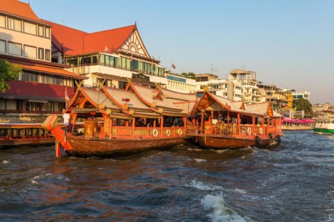 Ships at the pier for river cruise on a rice barge on the Chao Phraya river in Bangkok. Traditional