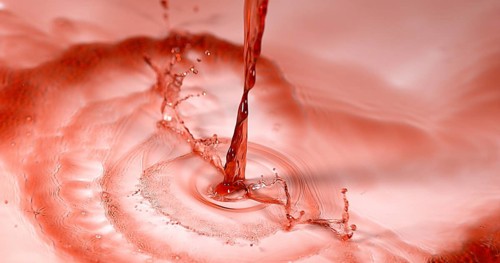 Red Wine being poured against White Background
