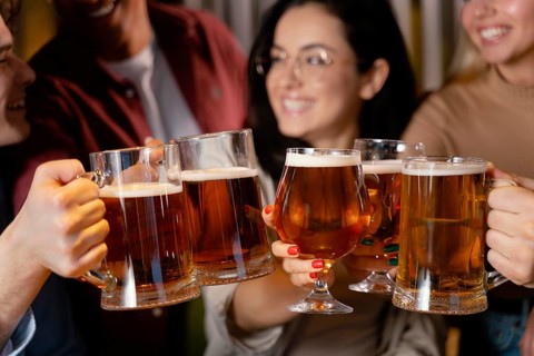 Close up smiley friends with beer mugs