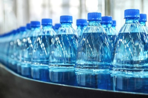 Closeup on mineral water green bottles in raw and lines