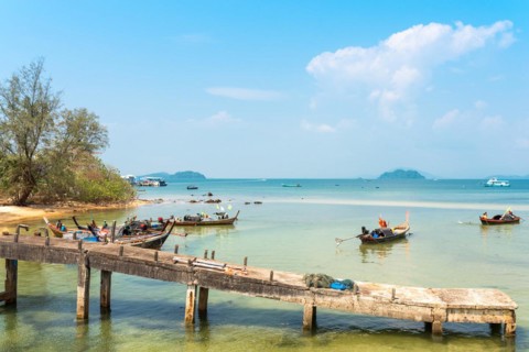Locals on the beach and on their long-tail boats at the west side beach Ao Mae Mai on the island Ko