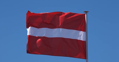 Latvian Flag Waving in the Wind against blue sky
