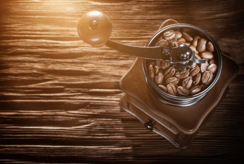 Coffee grinder natural grains on vintage wooden board